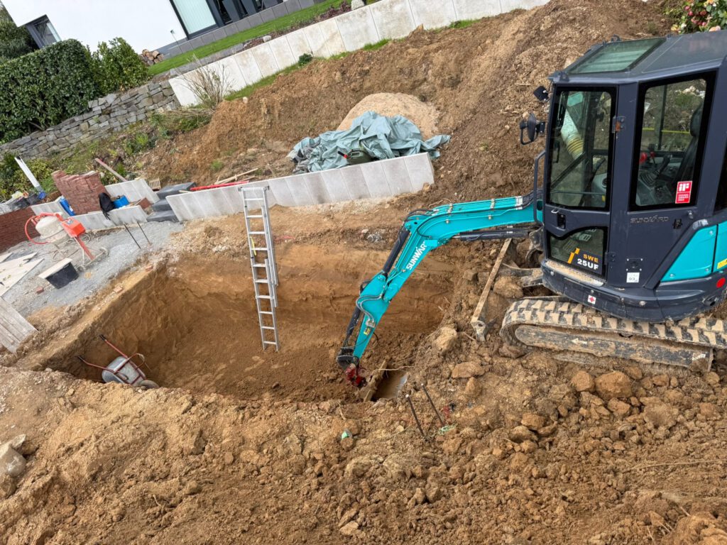 Bagger von ATTA-BAU beim Aushub am Hang in Burscheid
